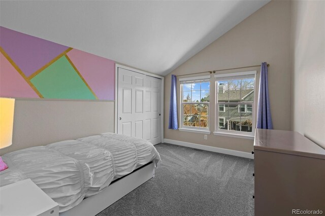 carpeted bedroom with a closet, baseboards, and lofted ceiling