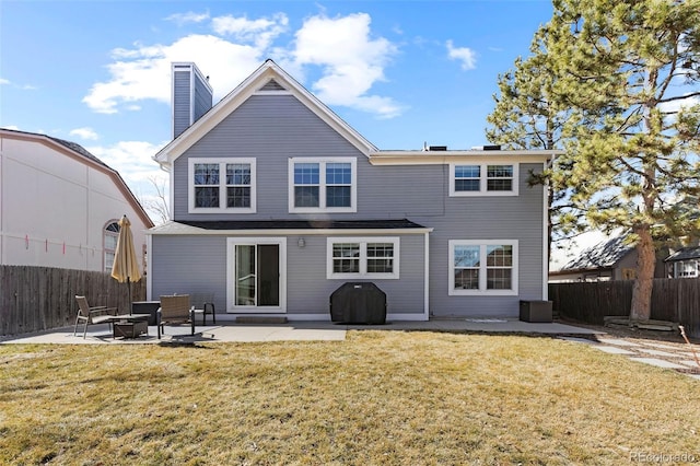 rear view of house featuring a lawn, a patio, and fence