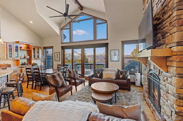 85 Uncle Sam Lode, Breckenridge, CO 80424 - living area featuring a ceiling fan, high vaulted ceiling, light wood finished floors, a stone fireplace, and beam ceiling