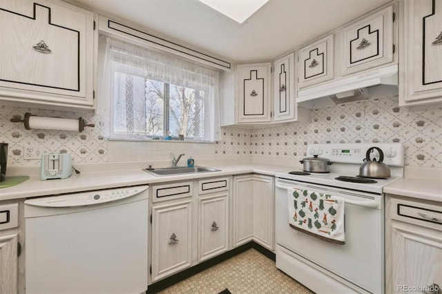 kitchen with white appliances, a sink, light countertops, under cabinet range hood, and backsplash