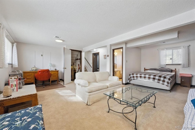 bedroom featuring visible vents, a textured ceiling, and carpet