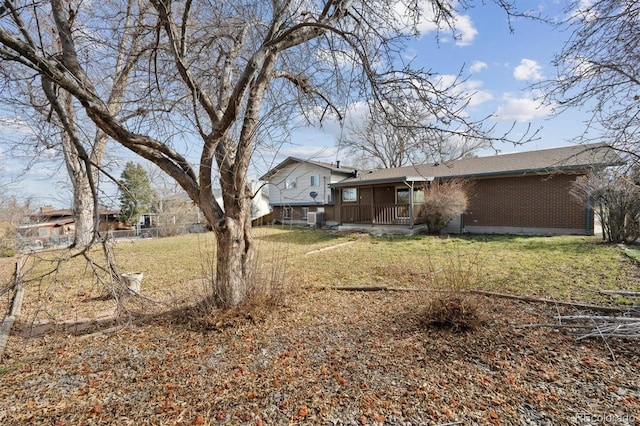 view of yard with a porch and central AC unit