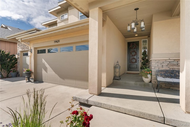 19429 W 88th Dr, Arvada, CO 80007 - view of exterior entry featuring stucco siding, driveway, and stone siding