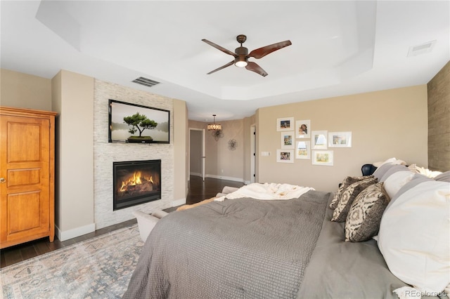 19429 W 88th Dr, Arvada, CO 80007 - bedroom with a tray ceiling, wood finished floors, a fireplace, and ceiling fan