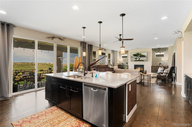 19429 W 88th Dr, Arvada, CO 80007 - kitchen with dishwasher, a fireplace, ceiling fan, dark wood-style floors, and a kitchen island with sink