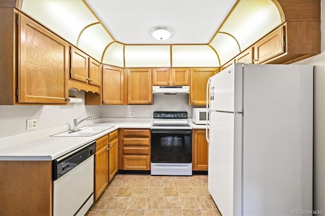 3082 S Wheeling Way Unit 202, Aurora, CO 80014 - kitchen featuring white appliances, under cabinet range hood, a sink, light countertops, and brown cabinetry