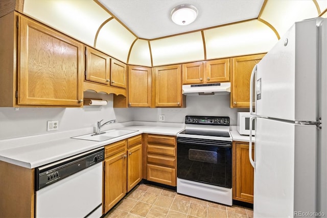 3082 S Wheeling Way Unit 202, Aurora, CO 80014 - kitchen featuring white appliances, a sink, under cabinet range hood, light countertops, and brown cabinetry