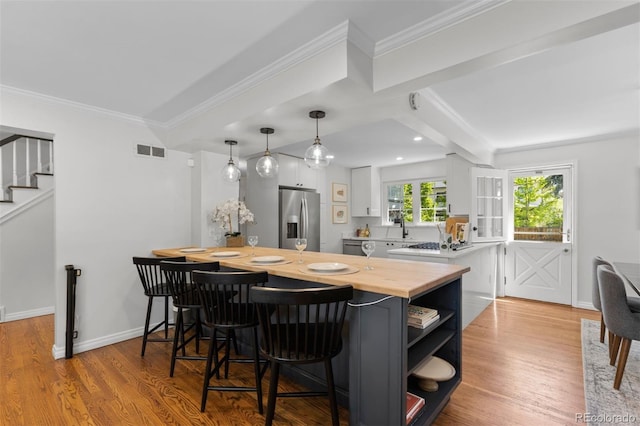 400 Holly St, Denver, CO 80220 - kitchen with stainless steel refrigerator with ice dispenser, open shelves, a peninsula, a breakfast bar, and white cabinets