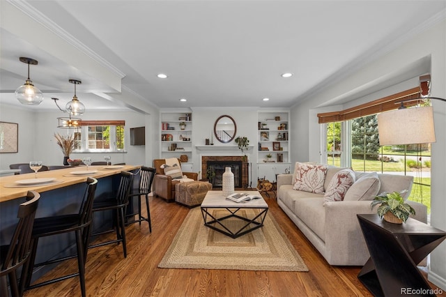 400 Holly St, Denver, CO 80220 - living room featuring wood finished floors, plenty of natural light, a brick fireplace, recessed lighting, and crown molding