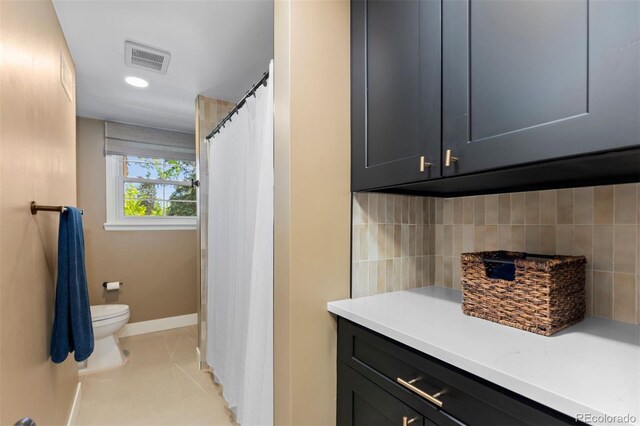 400 Holly St, Denver, CO 80220 - full bathroom with toilet, tasteful backsplash, baseboards, tile patterned floors, and a shower with curtain