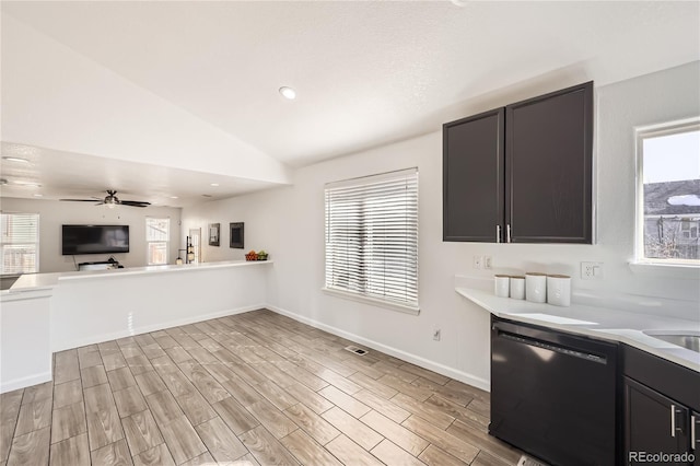 kitchen featuring ceiling fan, vaulted ceiling, dishwasher, and light wood-type flooring