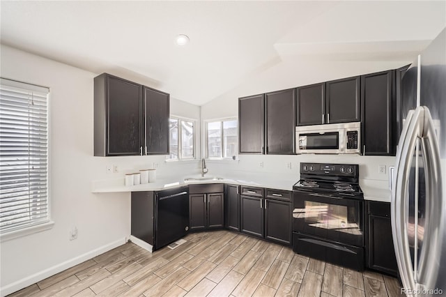 kitchen with lofted ceiling, sink, and black appliances