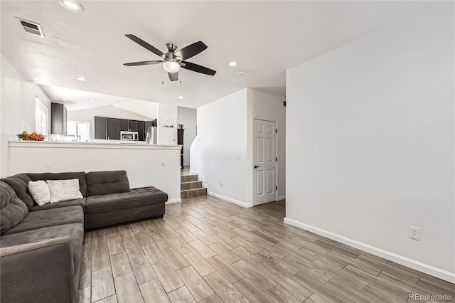 living room with lofted ceiling, light hardwood / wood-style flooring, and ceiling fan