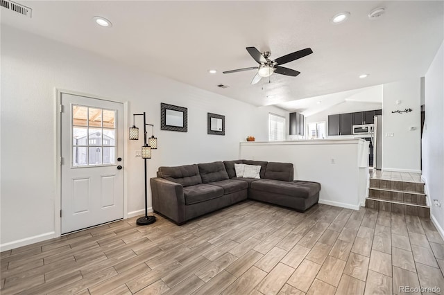 living room featuring ceiling fan, plenty of natural light, and vaulted ceiling