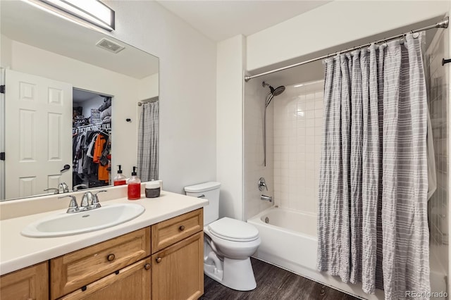 full bathroom featuring vanity, hardwood / wood-style floors, shower / tub combo with curtain, and toilet