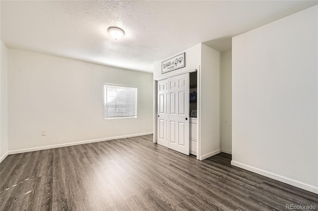 unfurnished room featuring dark hardwood / wood-style floors and a textured ceiling