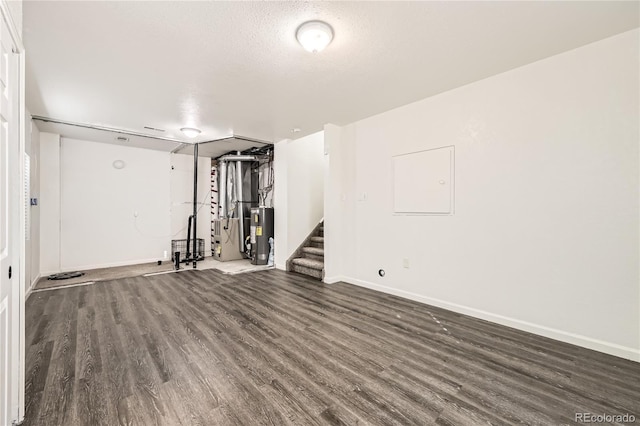 interior space with dark hardwood / wood-style floors, water heater, and a textured ceiling