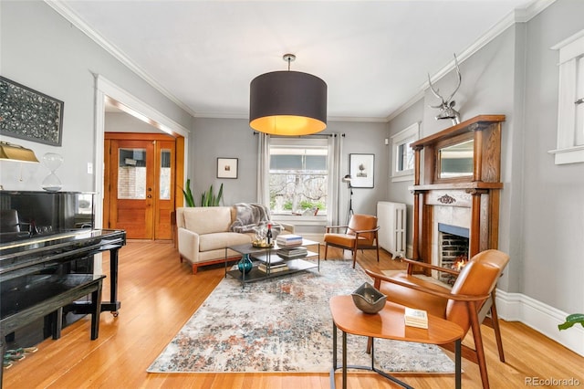 3701 Eliot St, Denver, CO 80211 - living room featuring radiator, wood finished floors, a warm lit fireplace, and crown molding