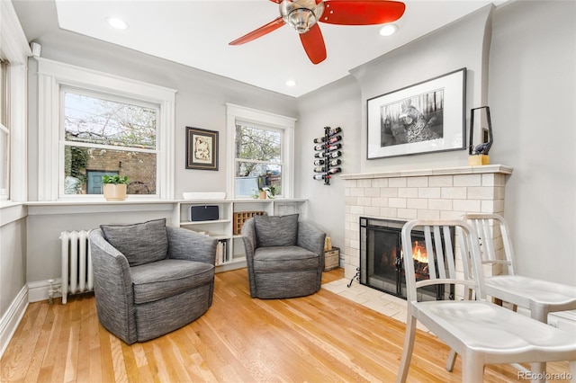 3701 Eliot St, Denver, CO 80211 - living area with radiator, wood finished floors, ceiling fan, a fireplace, and recessed lighting