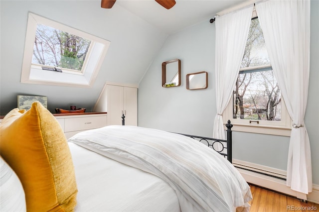 3701 Eliot St, Denver, CO 80211 - bedroom with a baseboard radiator, vaulted ceiling, multiple windows, and light wood-style flooring