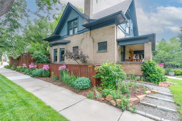 3701 Eliot St, Denver, CO 80211 - view of home's exterior with brick siding, a chimney, and a shingled roof