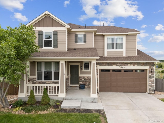 3620 Sandoval St, Brighton, CO 80601 - view of front of house featuring a porch, driveway, an attached garage, stone siding, and roof with shingles