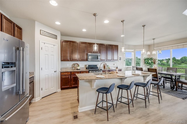 3620 Sandoval St, Brighton, CO 80601 - kitchen with appliances with stainless steel finishes, light wood-style floors, light stone countertops, decorative light fixtures, and recessed lighting