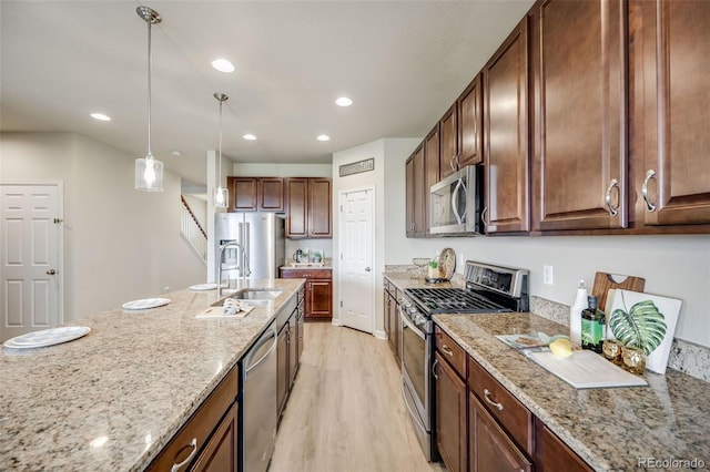 3620 Sandoval St, Brighton, CO 80601 - kitchen with appliances with stainless steel finishes, light wood-type flooring, light stone countertops, decorative light fixtures, and recessed lighting