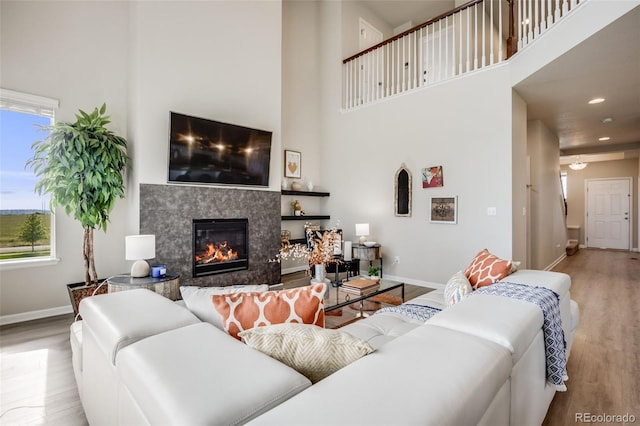 3620 Sandoval St, Brighton, CO 80601 - living area with wood finished floors, a towering ceiling, a premium fireplace, and recessed lighting