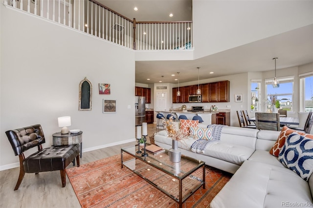 3620 Sandoval St, Brighton, CO 80601 - living room with light wood-style floors, a towering ceiling, and recessed lighting
