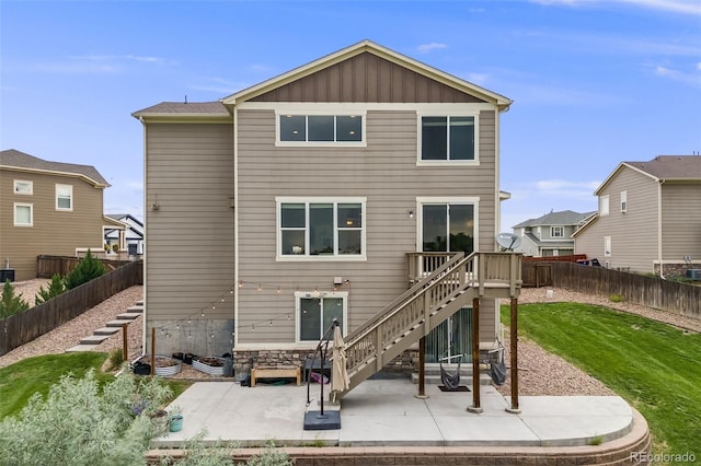3620 Sandoval St, Brighton, CO 80601 - back of property with stairs, a patio, a fenced backyard, and board and batten siding