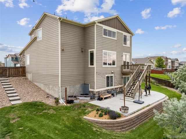 3620 Sandoval St, Brighton, CO 80601 - back of property with stairway, a patio area, board and batten siding, and a deck
