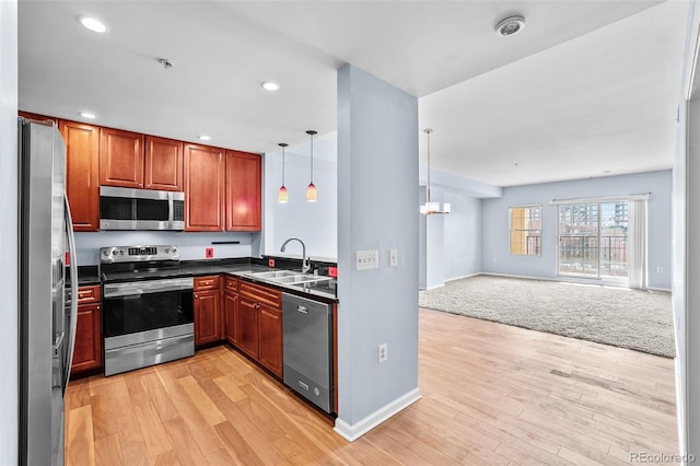 kitchen with a sink, dark countertops, open floor plan, baseboards, and appliances with stainless steel finishes
