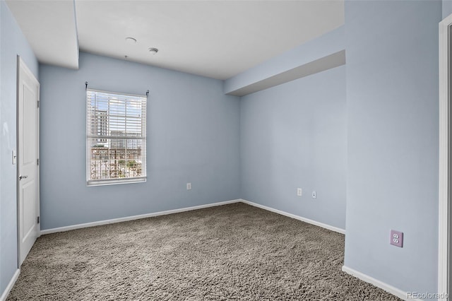 unfurnished room with carpet floors and baseboards