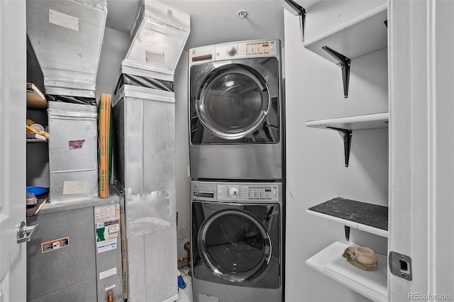 clothes washing area featuring stacked washing maching and dryer and laundry area
