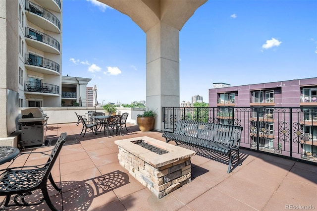 view of patio / terrace with a grill, outdoor dining area, and a fire pit