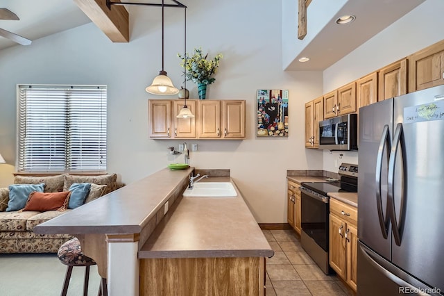 846 Blue River Pkwy Unit C2, Silverthorne, CO 80498 - kitchen with a breakfast bar area, light tile patterned floors, a sink, a peninsula, and appliances with stainless steel finishes