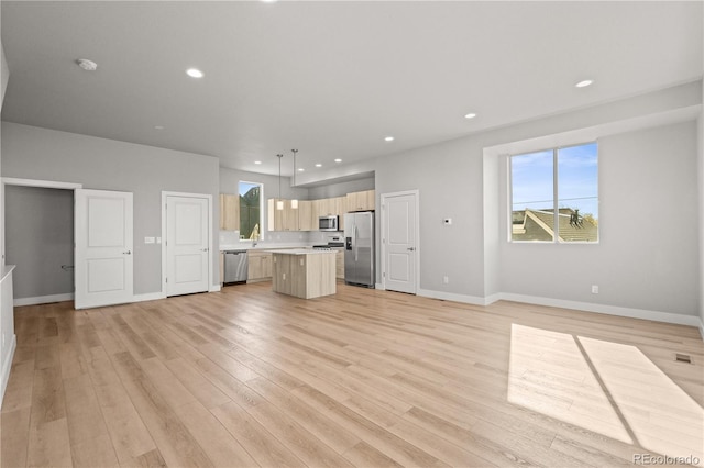 unfurnished living room with recessed lighting, light wood-style floors, and baseboards