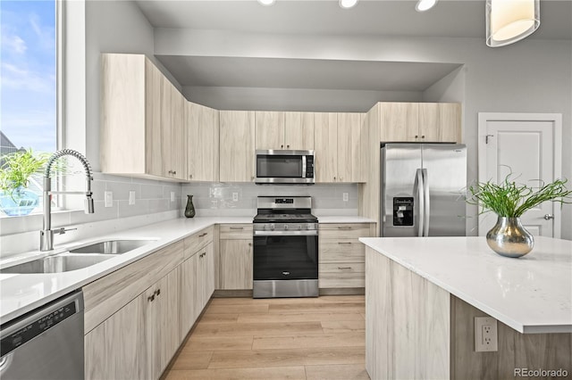 4737 E Iliff Ave, Denver, CO 80222 - kitchen with appliances with stainless steel finishes, light brown cabinetry, decorative backsplash, light countertops, and light wood-type flooring