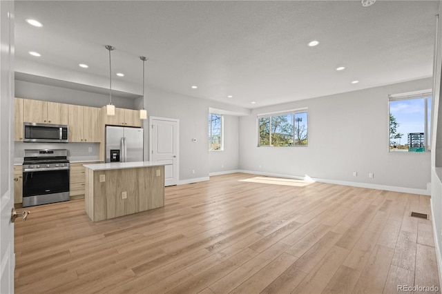 4737 E Iliff Ave, Denver, CO 80222 - kitchen featuring appliances with stainless steel finishes, light brown cabinets, recessed lighting, a kitchen island, and light countertops