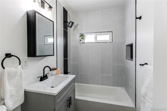 bathroom featuring tiled shower / bath combo and vanity