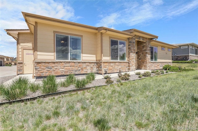12258 Hazel Spruce Ct, Parker, CO 80134 - view of home's exterior featuring stone siding and a lawn