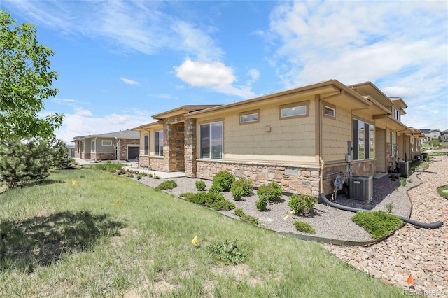 12258 Hazel Spruce Ct, Parker, CO 80134 - view of side of home with stone siding, central AC, and a yard