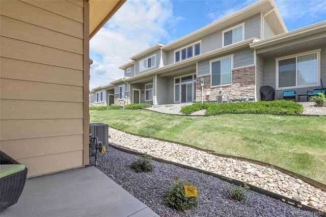 12258 Hazel Spruce Ct, Parker, CO 80134 - property entrance featuring stone siding, a yard, a patio area, and cooling unit