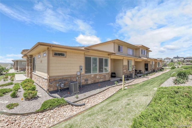 12258 Hazel Spruce Ct, Parker, CO 80134 - back of property featuring stone siding, a patio area, and central AC