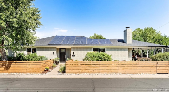 ranch-style house featuring solar panels