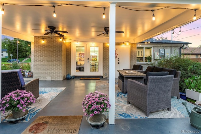 patio terrace at dusk featuring french doors, ceiling fan, and outdoor lounge area