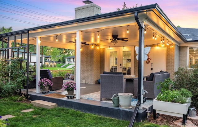 patio terrace at dusk featuring french doors and ceiling fan