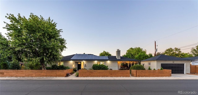 view of front facade with a garage and solar panels