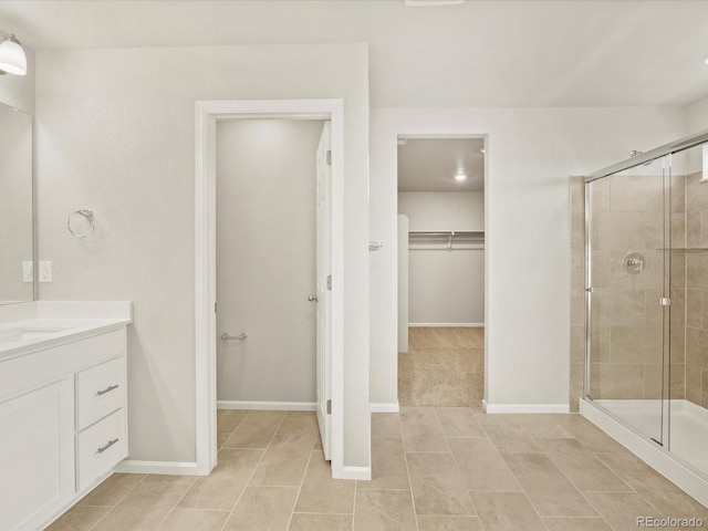 bathroom with a shower with shower door and vanity